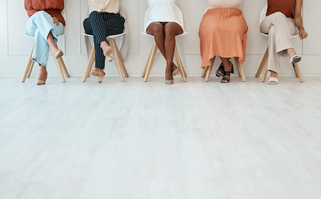 Foto entrevista de pés e mulheres de negócios esperando na fila para sua reunião com recursos humanos durante o recrutamento pernas contratando e candidato com um grupo de pessoas sentadas em fila em uma agência para hr