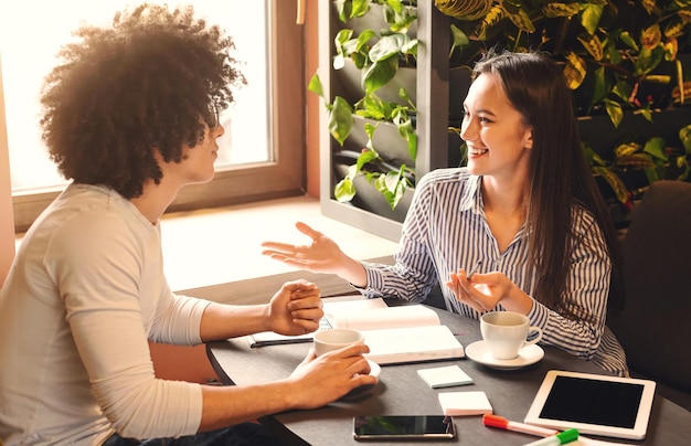 Entrevista informal de trabajo mujer alegre hablando con un nuevo candidato en el espacio libre de la cafetería