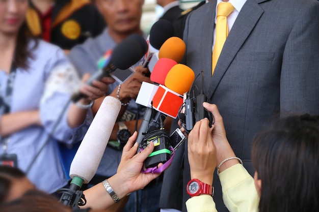 Foto entrevista con los medios de comunicación conept.ggrup de periodistas con micrófono para entrevistar a vip