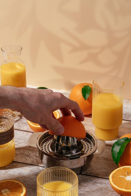 Entsafter für frisch gepressten Orangensaft auf einem Holztisch in einem Glas Orangen