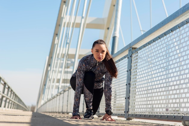 Entschlossene junge Frau bereit für einen Sprint