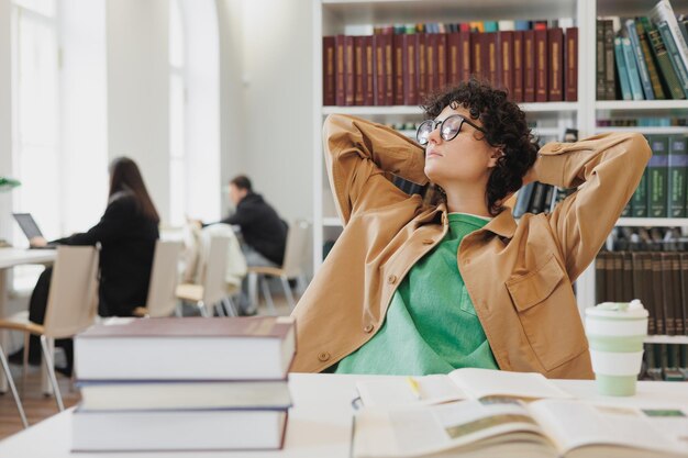 Entspannen Sie sich Frau arbeitet in Bibliothek Coworking oder Büro junge Studentin schreibt Forschungsarbeit