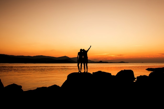 Entspannen Sie sich Zeit der Schwester auf dem Strandsonnenunterganghintergrund