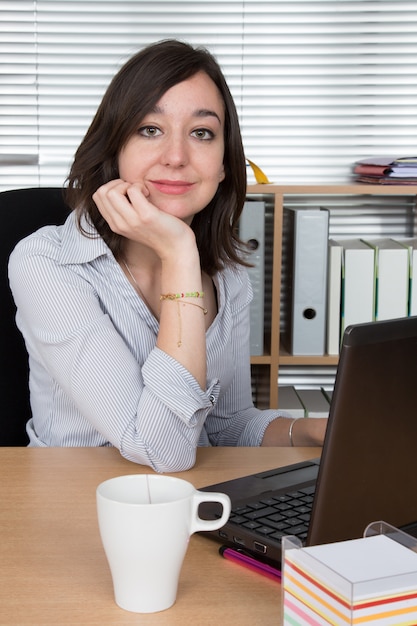 Entspannende junge Geschäftsfrau in einem hellen Büro
