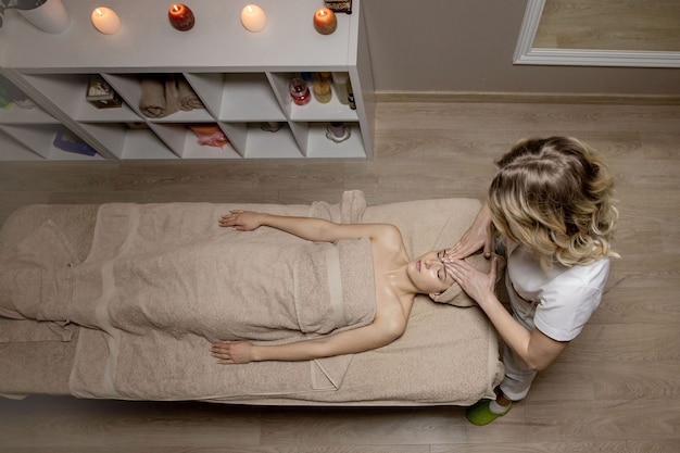 Entspannende Massage. Frau empfängt Kopfmassage im Spa-Salon, Seitenansicht.