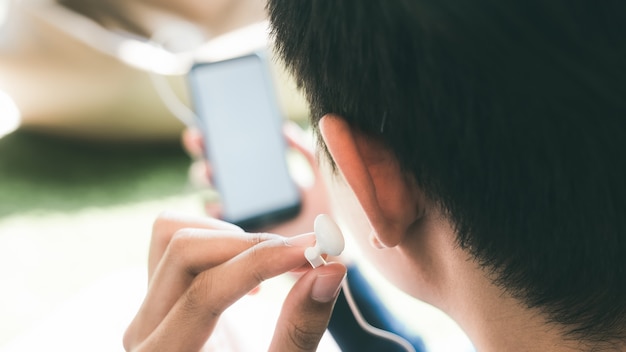 Foto entspannendes hören des jungen mannes die musik vom handy.