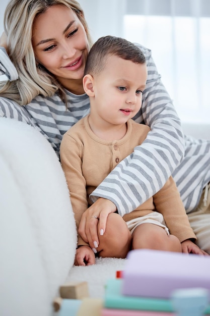 Entspannte Eltern ruhen sich mit Sohn im Vorschulalter im Wohnzimmer auf dem heimischen Sofa aus und sehen sich die hübsche Seite an ...