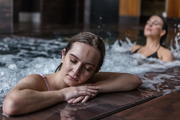 Entspannte Frau, die Hydromassagetherapie im Pool erhält