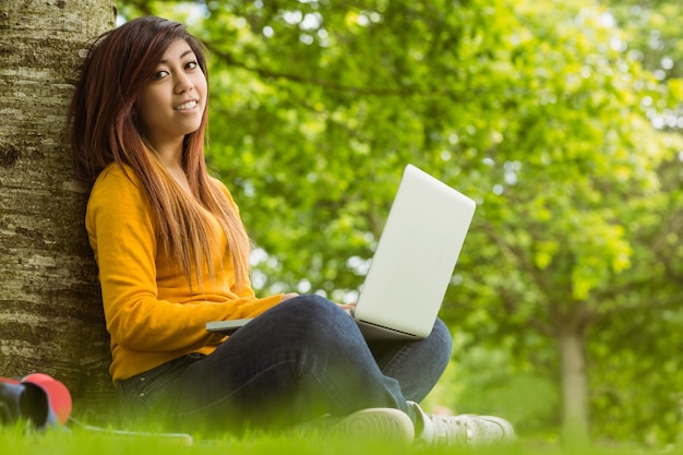 Entspannte Frau, die Laptop im Park verwendet