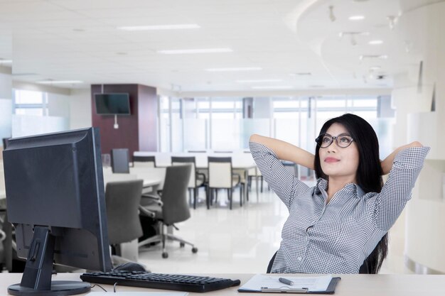 Entspannte Geschäftsfrau sitzt im Büro