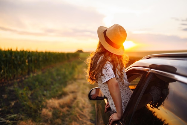 Entspannte, glückliche Frau auf einem Sommer-Road-Trip, Reise, Urlaub, aus dem Autofenster lehnend, Lebensstil