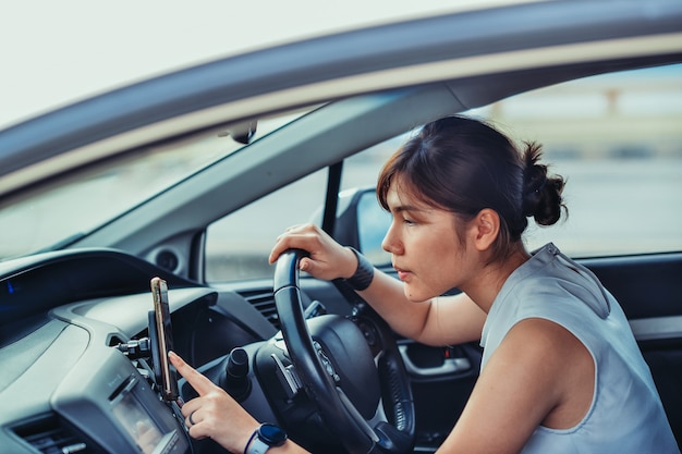 Entspannte, glückliche, zierliche Frau im Reiseurlaub. auf dem Auto sitzen und eine Route suchen. Lifestyle- und People-Konzept.