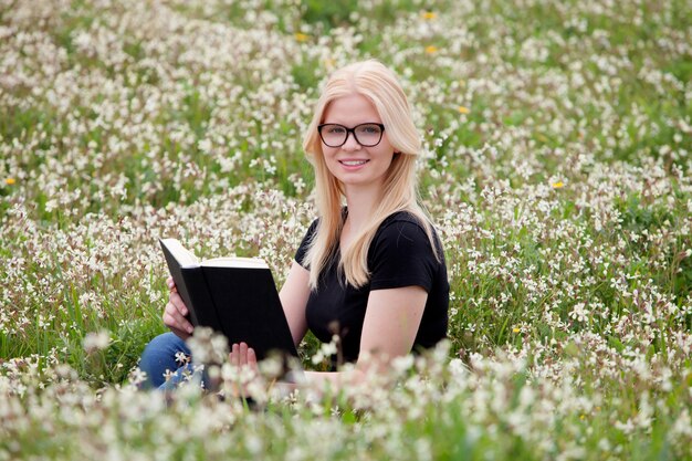 Entspannte junge Frau, die ein Buch liest