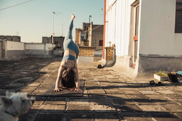 Entspannte junge Frau, die Yoga auf einer Dachterrasse praktiziert.