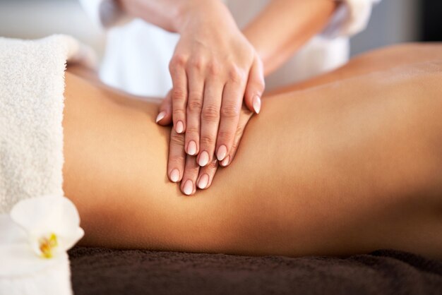 Entspannte lächelnde Frau, die eine Rückenmassage in einem Spa erhält