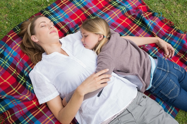 Entspannte Mutter und Tochter, die am Park liegen