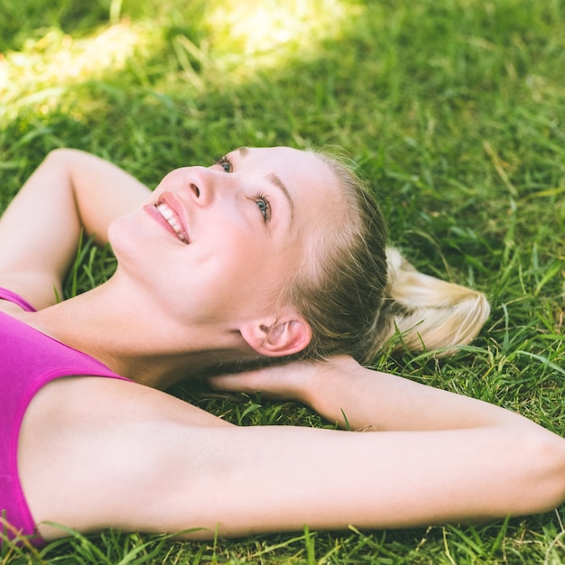 Entspannte Schönheit, die auf Gras im Park liegt