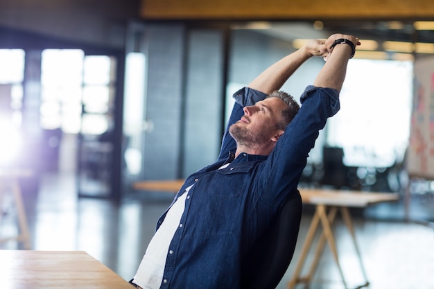 Entspannter Mann, der im Büro sitzt