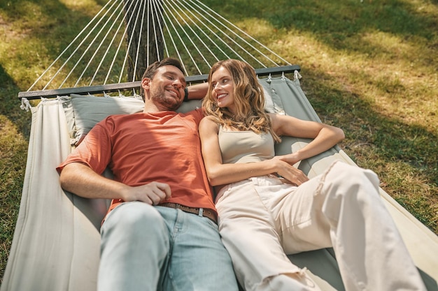 Entspannung. Ein Mann und eine Frau liegen in einer Hängematte und fühlen sich entspannt