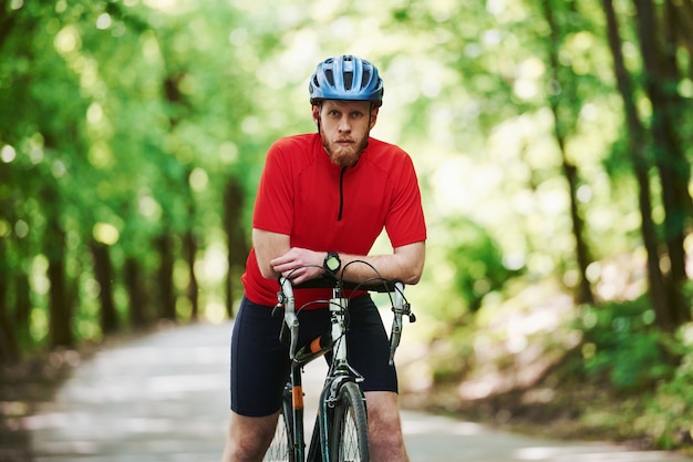 Entspannung zwischen Marathon. Radfahrer auf einem Fahrrad ist auf der Asphaltstraße im Wald am sonnigen Tag