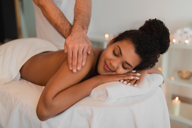 Entspannungsmassage für eine afroamerikanische Frau in einem Wellness-Spa