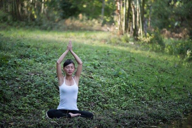 Entspannungszeit schöne Frau, die Yogagartenfeld spielt