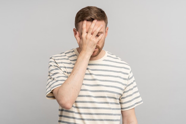 Foto enttäuschter, gestresster mann mittleren alters, der mit der hand eine gesichtspalme macht und sich für den fehler verantwortlich macht