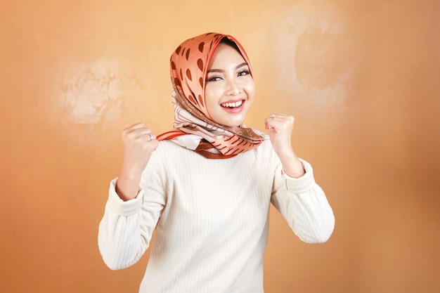 Entusiasta de linda mulher muçulmana comemorando sim o conceito de sucesso