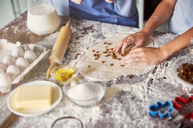 Entusiastas de la cocina haciendo masa con pasas para galletas