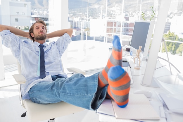 Entwerfer, der am Schreibtisch ohne Schuhe sich entspannt