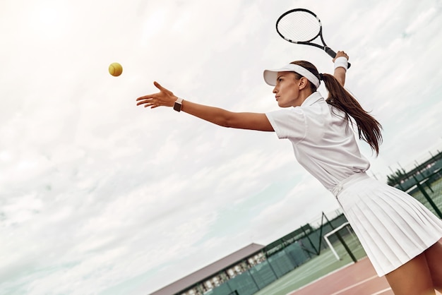 Entwickeln Sie Ihre Fähigkeiten attraktive Sportlerin wirft den Ball in die Luft