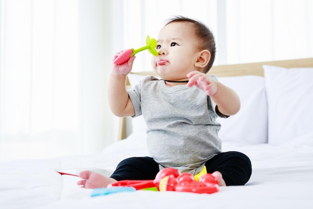 Entwicklung bei Kindern hübsches Baby spielt Babyspielzeug auf dem Bett