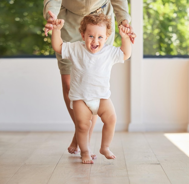 Entwicklung beim Gehen und Babylernen mit der Mutter, die dabei hilft, den Wachstumsfortschritt und die ersten Schritte ihres Kindes zu unterstützen Lächeln Sie glücklich und die Eltern halten Händchen mit ihrem Kind, das ihrem aufgeregten Sohn das Stehen beibringt