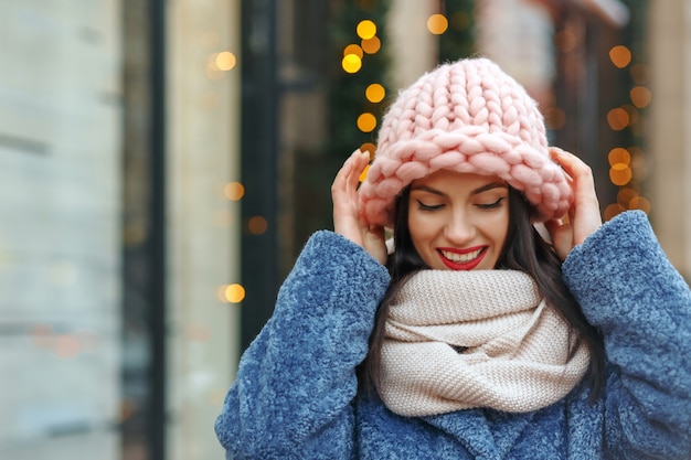 Entzückende brünette Frau im Mantel, die im Winter in die Stadt geht. Freiraum