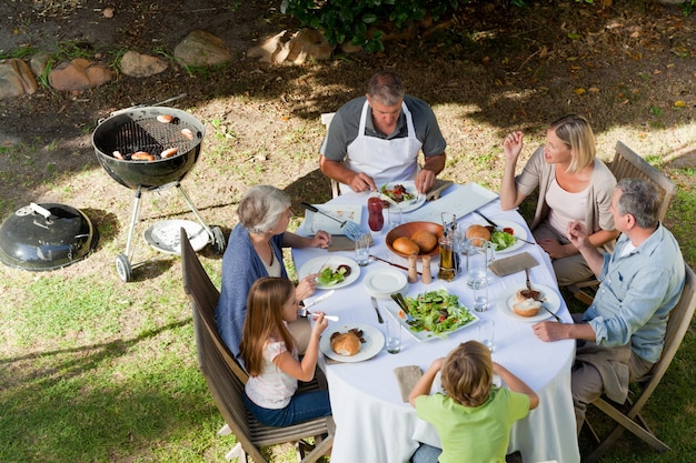 Entzückende Familie, die im Garten isst