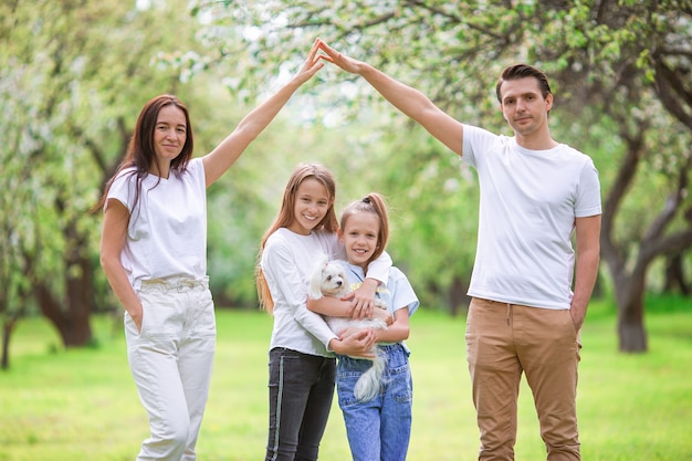 Entzückende Familie im blühenden Kirschgarten am schönen Frühlingstag