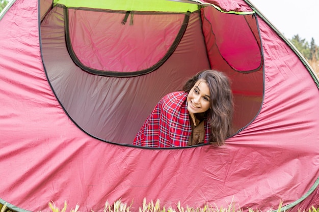 Entzückende junge Dame, die im Zelt sitzt und lächelt