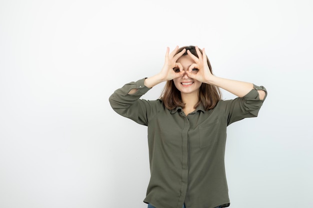 Entzückende junge Frau im lässigen Outfit, das steht und posiert. Foto in hoher Qualität