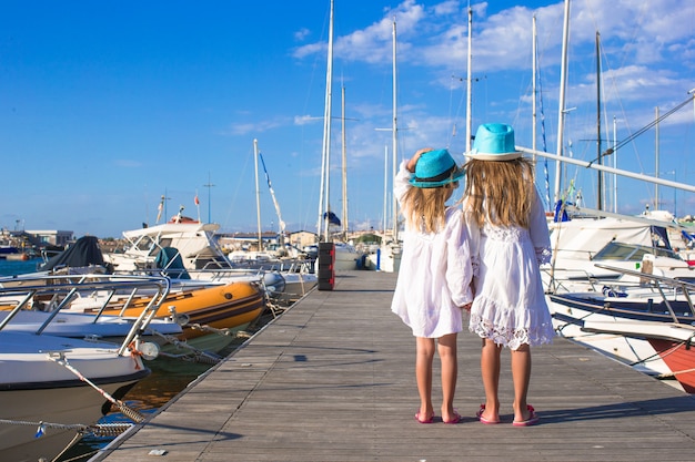 Entzückende kleine Mädchen, die in einen Hafen am Sommertag gehen