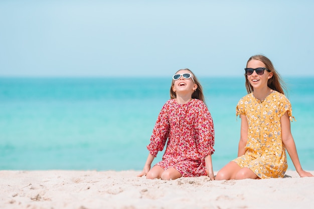 Entzückende kleine Mädchen haben Spaß am tropischen Strand während des Urlaubs