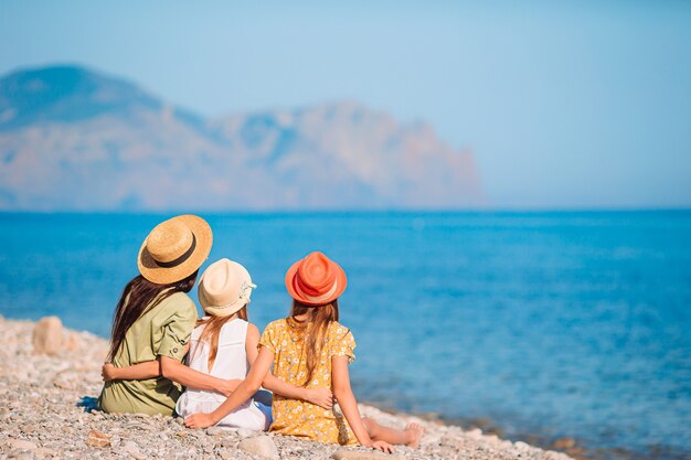 Entzückende kleine Mädchen und junge Mutter am tropischen weißen Strand