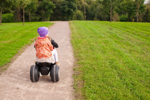 Entzückende kleine süße Mädchen fahren draußen ein Motorrad