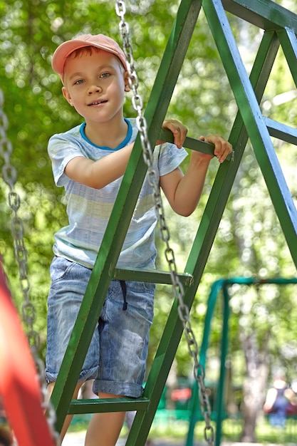 Entzückender Junge auf dem Sommerspielplatz