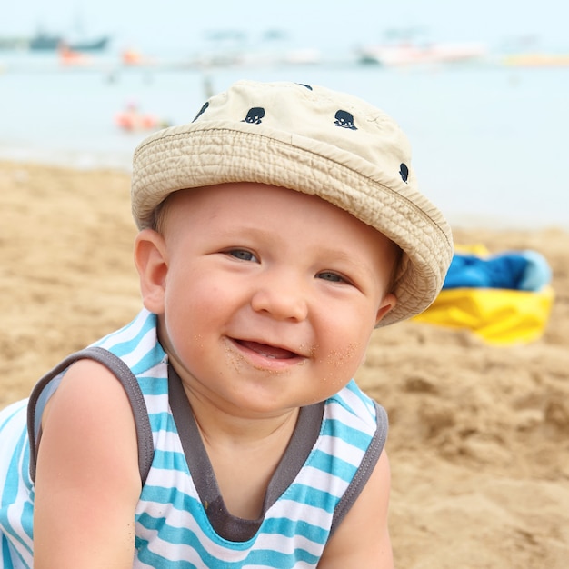 Entzückender kleiner Junge auf einem Sandstrand