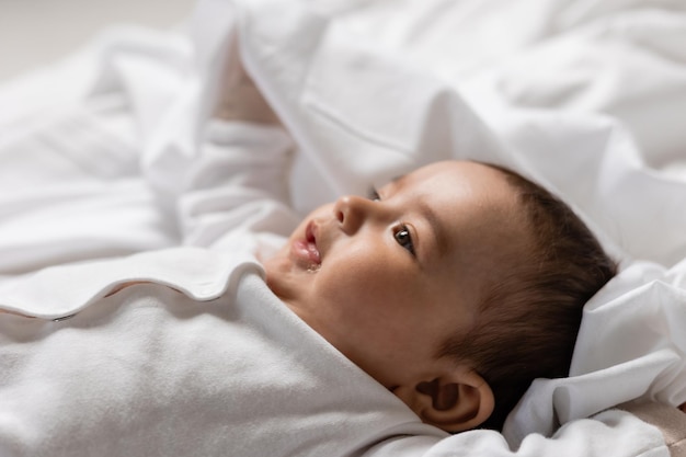 entzückender kleiner junge, der auf decke karte banner gesundheit legt