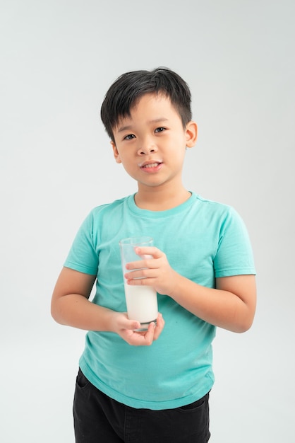 Entzückender kleiner Junge mit Glas Milch auf weißem Hintergrund