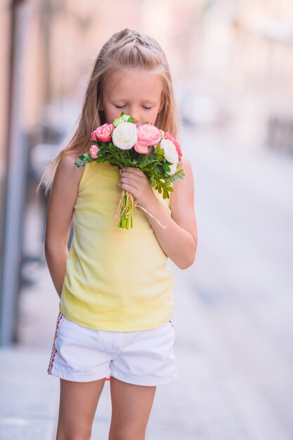 Entzückender riechender Blumenblumenstrauß des kleinen Mädchens