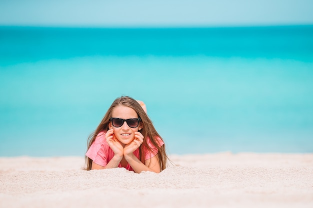 Entzückendes aktives kleines Mädchen am Strand während der Sommerferien