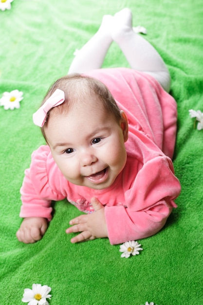 Entzückendes Baby, das auf Wiese liegt und lächelt