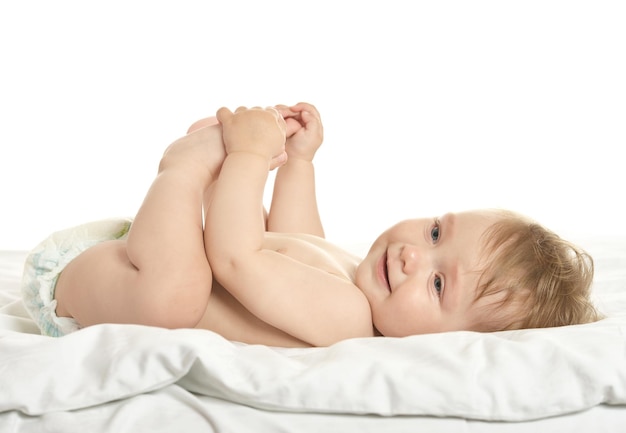 Entzückendes Baby, das in Pampers auf Decke auf weißem Hintergrund liegt
